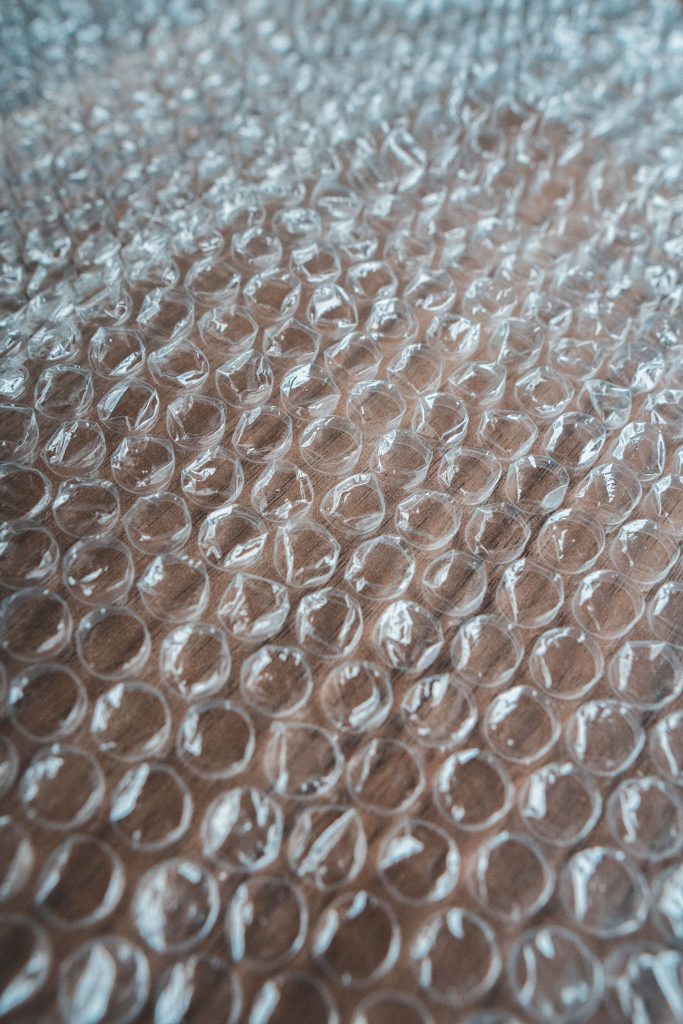 High angle of textured backdrop representing translucent bubble wrap sheet with bumpy surface in shiny light