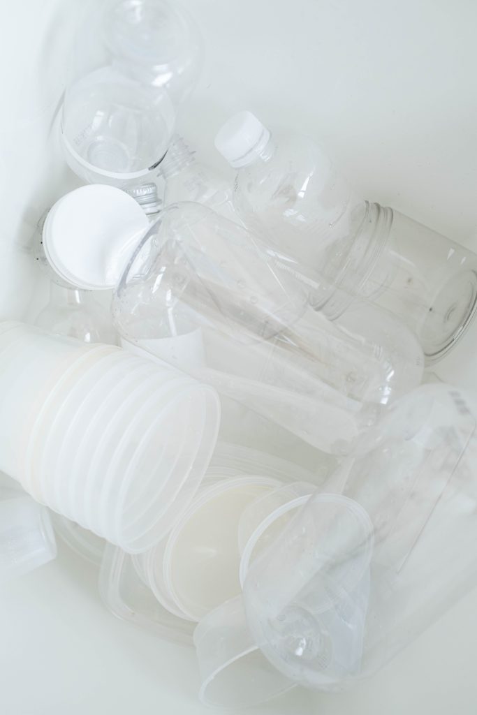 Collection of translucent plastic bottles and cups ready for recycling.